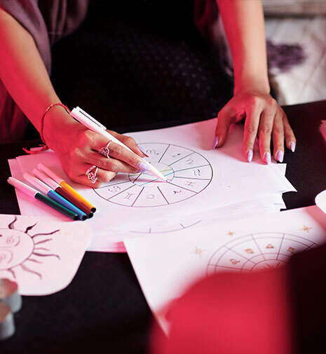woman drawing someone's astrological birth chart