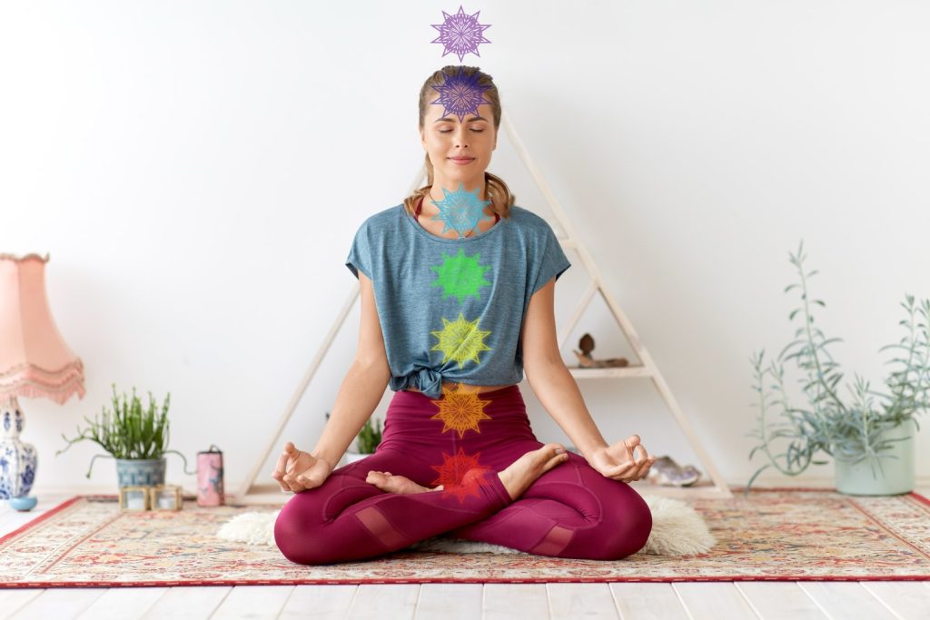 woman in meditative pose with chakras pictured